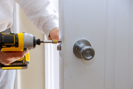 installation of locks on the door Hands repairing a door lock with a screwdriverの写真素材