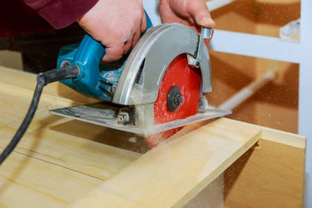 Handyman using hand-held saw machine carpenter using a circular saw