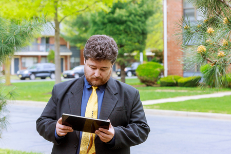 Businessman outside office buying online with a credit card and a tablet in the streetの写真素材