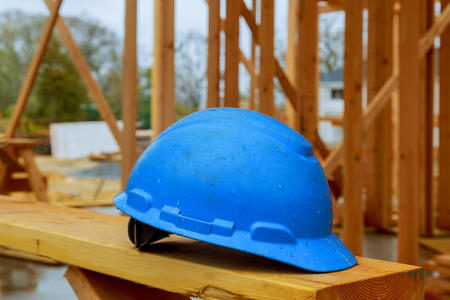 Construction work safety helmets for professional builders are placed on wooden boards. Safety...