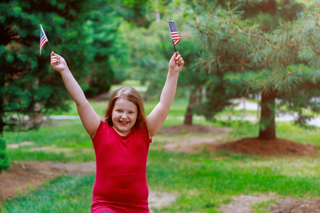 Funny little girl with waving american flag. Independence Day, Flag Day concept.の写真素材