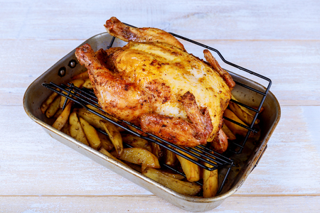 baked whole chicken with oranges and potatoes on a plate. Chicken Grill Baked in Ovenの写真素材