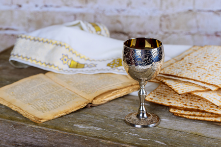 Jewish holidays Passover Pesach matzah and silver cup full of wine with a traditional blessing kiddush cup of wineの写真素材