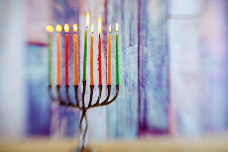 Menorah with candles for Hanukkah against defocused lights, close up