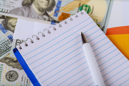 Top view, working table with financial notebook, graphs, reports dollars us currency. Business concept profit, income.の写真素材