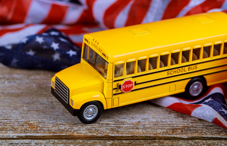 toy yellow school bus taking school and US flagの写真素材