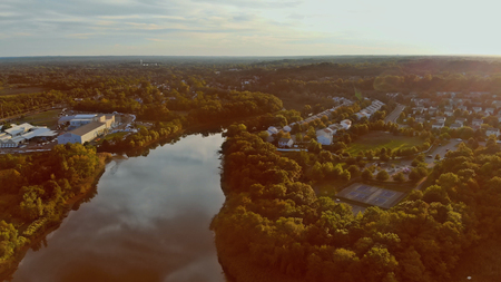 Magic sunset on colorful sunset over the city Top view of the river by trees and meadowsの写真素材