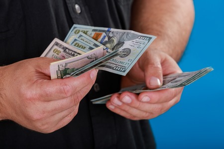 Close up Business man business concept counting the money man counting USA one hundred Dollar bills.