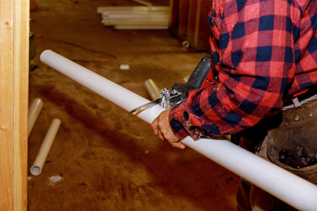 Worker in sawing PVC pipes,Industry Construction process to prepare cutting of water supply.