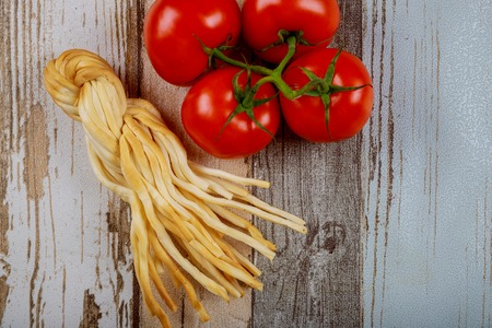 Smoked cheese on wooden boards, and red tomatoes