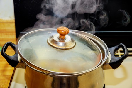 Boiling chicken and pork rip soup or boiled water in hot in pot boiling foodの写真素材