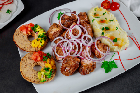 Roasted grilled skewers pork meat with mashed potatoes in white plate on tableの写真素材