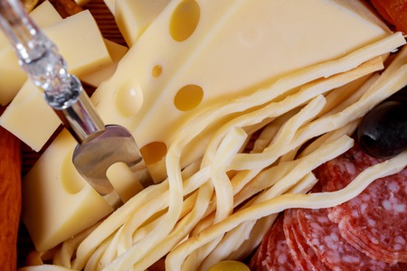 Different kinds of cheese, olives and sausage meat and cheese plate