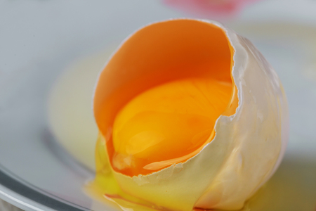 close up broken one chicken egg on white backgroundの写真素材