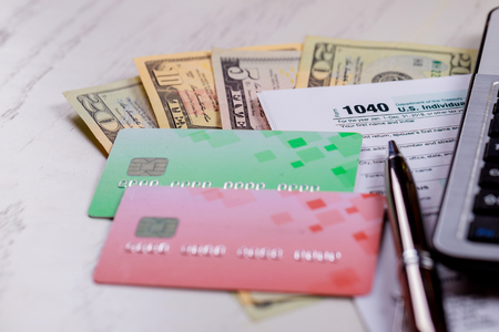 Business concept pay tax USA Tax Form 1040 with US dollar bills and for April Calendarの写真素材