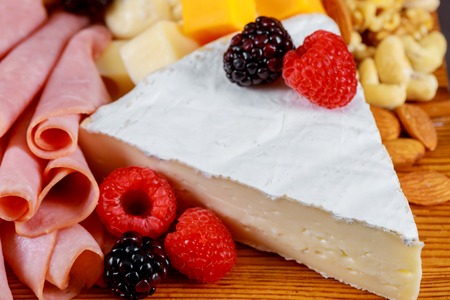 Beautiful collection set decor, nuts and berries on fresh assorted cheese, top view compositionの写真素材