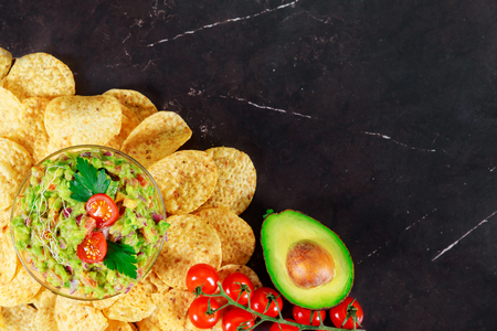 Guacamole doritos with nachos and avocado on stone dark backgroundの写真素材