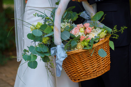 Woman in white dress holding a basket of flowers no face close upの写真素材