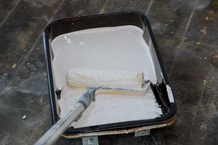 Set for realistic wall painting in paint tray and roller during interior paintingの写真素材