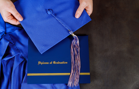 A graduation certificate diploma with graduation hat with empty space over wooden table. selective focusの写真素材