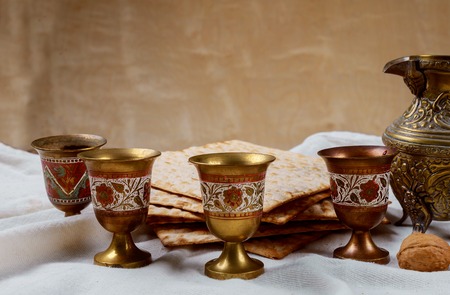 Passover matzoh jewish holiday bread and four glasses kosher wine over wooden table background.の写真素材