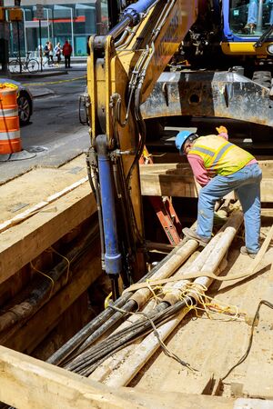 19 APRYL 2019 NY. USA Excavator dug a trench for replacement old pipes repair of city communications pipeline installationのeditorial素材
