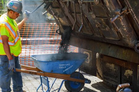 19 APRYL 2019 NY. USA Workers on a industry aying fresh asphalt bitumen during road construction...