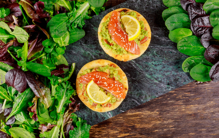 Toasts with avocado, smoked salmon, tomato and green salad