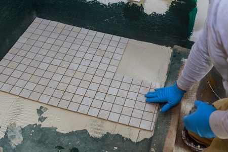 Troweling mortar a concrete floor in preparation for laying floor ceramic tilesの写真素材
