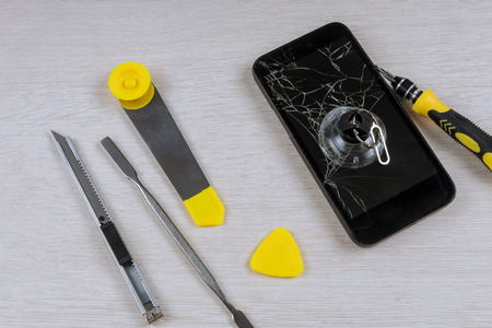 Smart phone repair with screwdriver with broken screenの写真素材