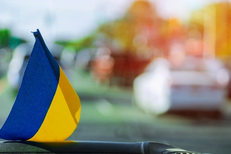 Patriotic sign Ukrainian flag on glass inside the car