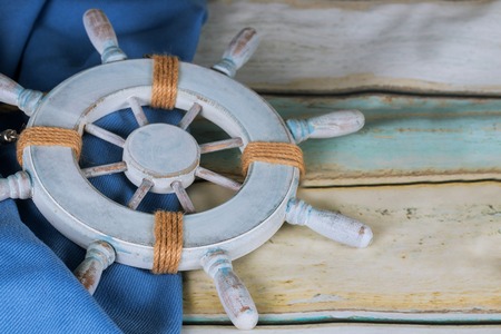 Light blue plank background with captain's seaman's helm summerの写真素材