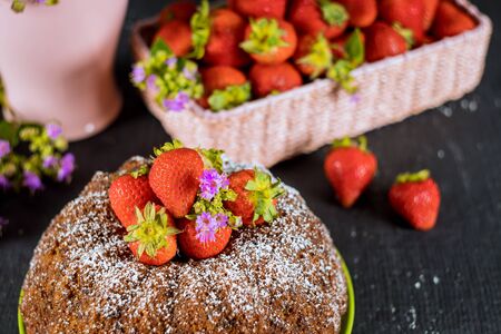 Pound vanilla cake and basket with fresh strawberries and flowers.の写真素材