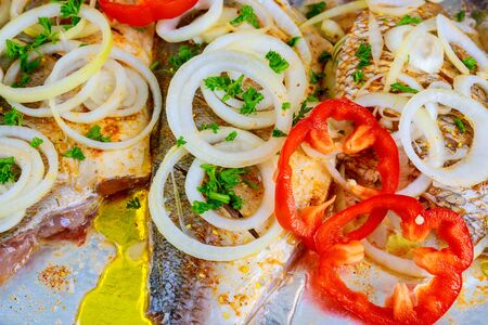 marinade is applied to a piece of fish on a slate metallic background. View from above. Preparation for cooking sea foodの写真素材