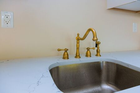 Close up of sinks in modern white kitchen with in designed luxury apartment white stone