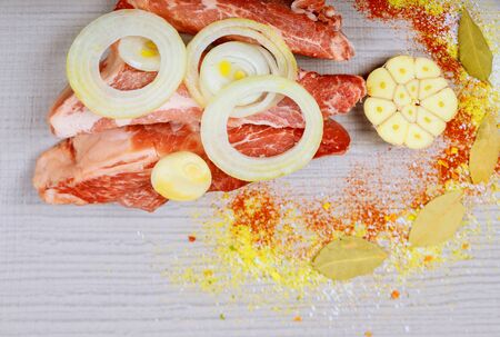 Raw pork steak on a white wooden table and spiceの写真素材