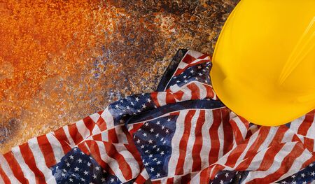 Construction yellow helmet and american flags with copy space for Labor day