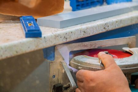 Carpenter using circular saw cutting wooden boards with hand power tools.