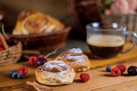 Homemade delicious cinnamon rolls sweet food with coffee and cinnamon sticks selective focusの写真素材