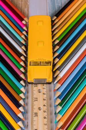 Back to school concept .School bus on ruler and colored pencils.