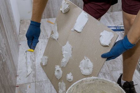 Plaster repair work laying tile, trowel in a man handの写真素材