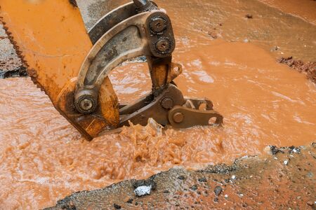 Water pipe break, leaking from hole in a road, pipe burst is repaired