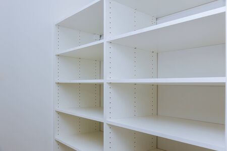 Interior of white plastic cabinet or clothing with many empty shelves with installation new homeの写真素材