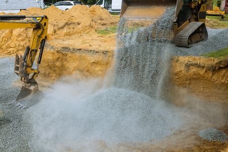 A bulldozer on wheels buried a excavator bucket working on the building under construction excavator...
