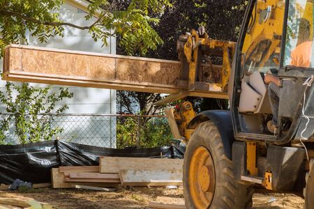 A construction worker installing silent floor forklift stacker loader joists in new constructionの写真素材