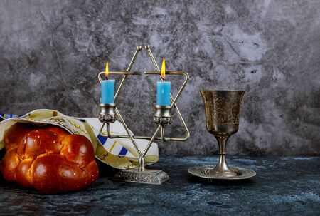 Sabbath Jewish Holiday homemade sesame challah bread and candelas on table