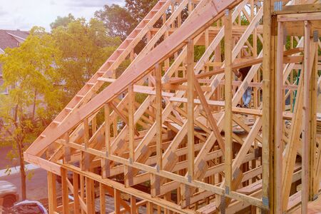 Panorama of modern condominium building with under construction wooden house with timber framing,...
