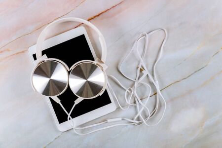 Technology digital tablet on marble background with headphoneの写真素材