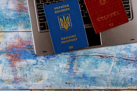 Ukrainian biometric passport and Hungarian passport in dual citizenship with computer keyboard...