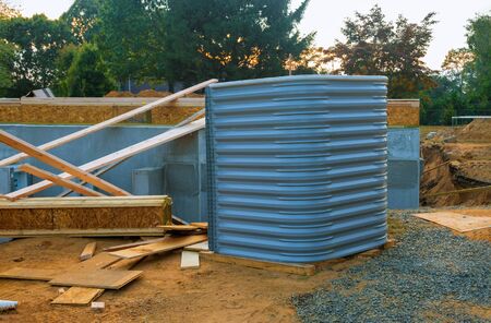 Building window well basement for new wood materials under construction home.